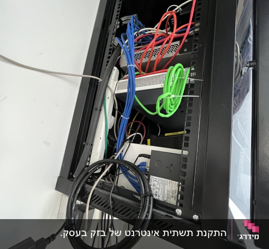 ארון תקשורת שחור פתוח ובו ציוד רשת וכבלי תקשורת מחוברים